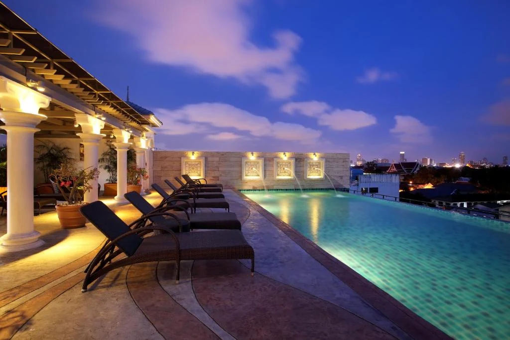 Rooftop infinity pool at Chillax Resort Bangkok lit at blue hour